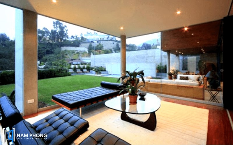 Vách kính cường lực phòng khách thay thế tường gạch cho resort view sân vườn