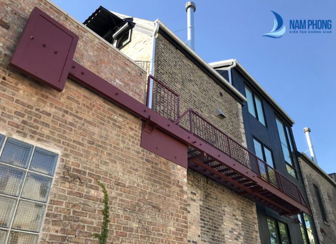 Mẫu cầu thang xương cá sơn đỏ nâu với công năng thoát hiểm an toàn