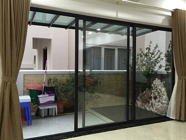 Mẫu cửa lùa 1 cánh làm ngăn khu giữa phòng khách và bếp, giúp không gian gọn gàng hơn